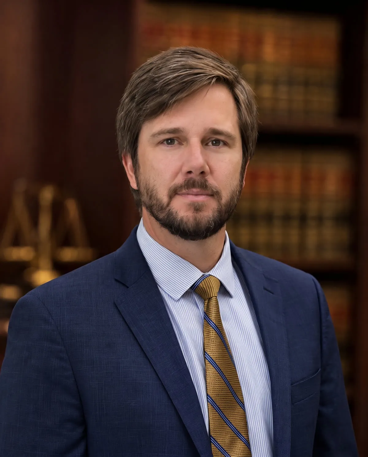 Attorney Jacob Ramsey in a navy suit in front of a wall of law books